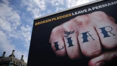 An advertisement van with the words "Liar Liar" emblazoned on the side drives around Parliament Square