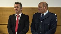 Phil Rudd and policeman in court in Tauranga, New Zealand (21 April 2015)