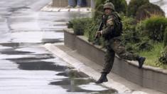 A police officer walks on a street as Macedonian special forces engage in a police action against an alleged group of unidentified armed group, in Kumanovo, Macedonia, 9 May 2015.