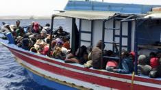 Migrants who attempted to sail to Europe sit in a boat carrying them back to Libya after their boat was intercepted at sea by the Libyan coast guard, at Khoms, Libya, 6 May 2015