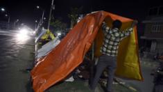 Kathmandu residents prepare makeshift tents on an avenue as they prepare to spend the night out in the open on 13 May