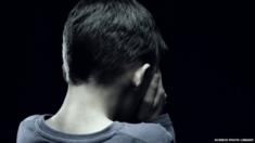 Unhappy boy covering his face with his hand