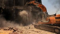 A bulldozer destroys the building of the headquarters of the once-dominant party of ex-president Hosni Mubarak that was torched during the 2011 uprising that toppled him on 31 May 2015 in Cairo.