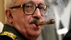 Tariq Aziz smokes a cigar during a meeting in Baghdad, Iraq - 18 September 2002