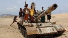 Fighters from the Southern Popular Resistance ride on a tank at the front line of fighting against Houthi fighters, on the outskirts of Yemen's southern port city of Aden (06 June 2015)