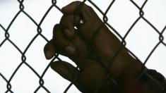 File photo: An inmate holds onto a fence at the Lousiana State Penitentiary, 23 April 2006, Angola, Louisiana, US