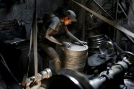 Un chico trabaja en una empresa de utensilios de aluminio en Daca, la capital de Bangladés.