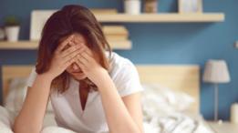 Una mujer que se cubre el rostro con las manos