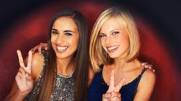 Dos mujeres haciendo el símoblo de la paz frente a la cámara.