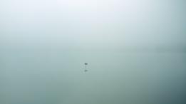 Un pequeño cartelito en la distancia en medio de un lago brumoso