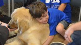 Niño abrazando a un perro.