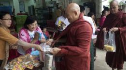 Personas donan comida a monjes budistas en Birmania