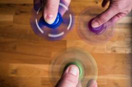 Tres personas hacen girar sus fidget spinners