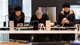 Tres jóvenes probando distintos modelos de celulares