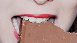 Una mujer comiendo una barra de chocolate