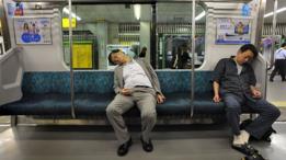 Dos pasajeros en Tokio toman una siesta en el metro.