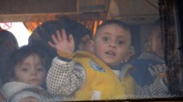 أطفال ونساء يستقلون الحافلات المغادرة لحمص
