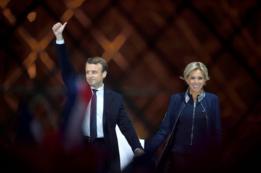 El presidente electo francés Emmanuel Macron y su mujer Brigitte Trogneux saludan a sus seguidores en frente de la Pirámide del Museo del Louvre Museum en París.