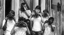 niños tomando fotografías con modelos antiguos de de Kodak.