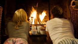 Dos personas frente a una chimenea