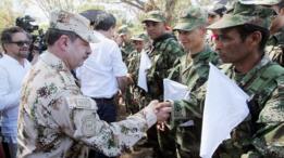 El comandante del ejército colombiano Javier Florez saluda a combatientes de las FARC que arribaron a una zona de transición.