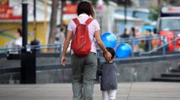 Mujer y niño caminando en la calle.