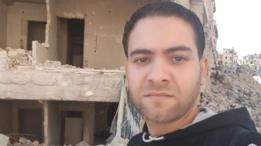 محمد يقف أمام ركام منازل مدمرة في حلب.