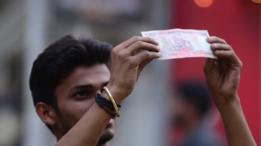 Hombre con uno de los billetes nuevos