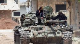 Un tanque de guerra recorriendo una calle polvorienta