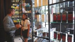 Una vendedora de perfumes con un cliente.