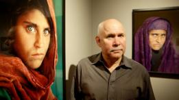 El fotógrafo Steve McCurry posa con las imágenes enmarcadas de Sharbat Gula, conocida como la 