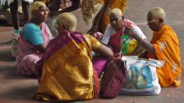 Mujeres reunidas después de que les han rasurado la cabeza en una ceremonia hindú en India.