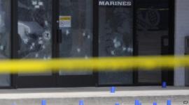 Gunshots in glass door below 'Marines' sign
