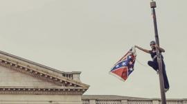 Bree Newsome takes down the Confederate Flag from a pole at the Statehouse in Columbia, South Carolina, June 27, 2015.