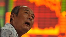 An investor gestures as he checks Chinese share prices