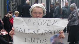 Elena Urlaeva holds up poster saying 