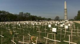 A temporary memorial of wooden crosses on the grass of the National Mall