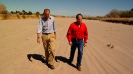Men walk in dried up Rio Grande River
