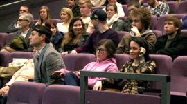 A cinema audience wearing equipment to monitor mood changes