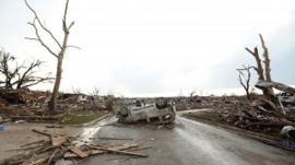 A vehicle lies upside down in the road
