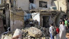 Two boys looking at rubble following explosion