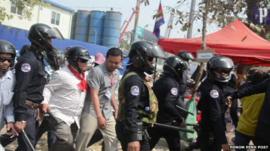 Police and civilians move in to clear the Phnom Penh park