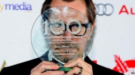 Gary Oldman hiding face with award