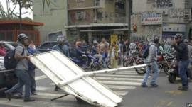 Demonstrators block a street with a traffic sign during a protest against the government of Venezuelan President Nicolas Maduro, in Caracas on 24 February, 2014