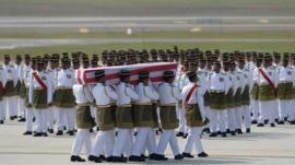 Coffins draped in the national flag were slowly carried to waiting hearses