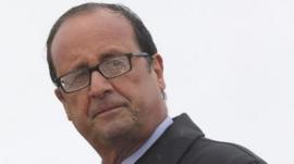 French President Francois Hollande delivers a speech in the rain on the Ile de Sein, an island located near the Pointe-du-Raz, off the Brittany coast, August 25, 2014