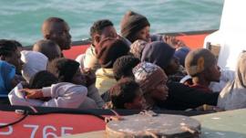 Migrants on a coast guard dinghy boat arrive at the Sicilian Porto Empedocle harbour