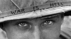 An unidentified American soldier wears a hand written slogan on his helmet in June 1965