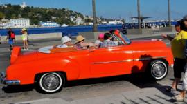 Tourists from the United States are seen in old American cars in Havana on 6 April, 2015.