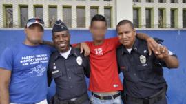 Two policemen pose with two former gang members in San Miguelito